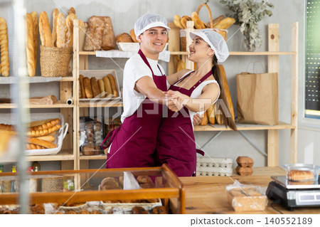 Two cheerful young bakers dancing playfully in bakery Two cheerful young bakers dancing playfully in bakery 140552189