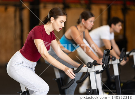 Woman exercising on an exercise bike 140552318