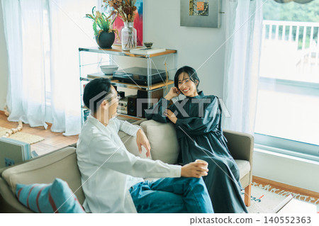 A young Japanese couple chatting with smiles on their faces. 140552363