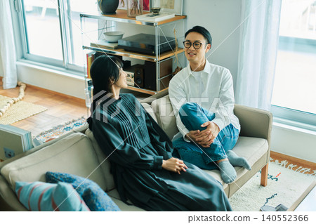 A young Japanese couple chatting with smiles on their faces. 140552366