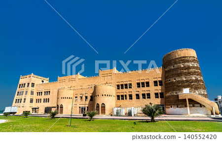 Exterior view of the Heritage Village tourist attraction in Dammam, Saudi Arabia, featuring traditional fortress architecture under a clear blue sky. Exterior view of the Heritage Village tourist attraction in Dammam, Saudi Arabia, featuring traditional fortress architecture under a clear blue sky. 140552420
