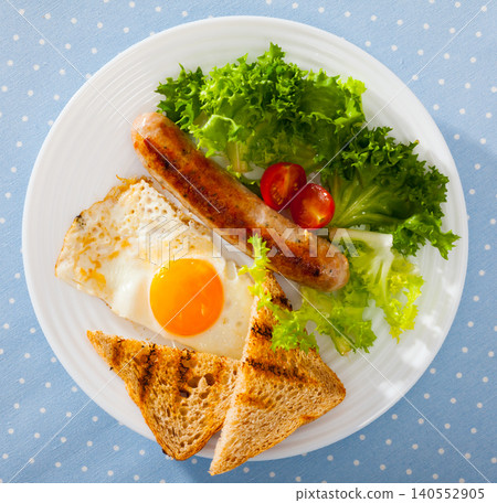 Top view of fried eggs with sausage, bread and vegetable Top view of fried eggs with sausage, bread and vegetable 140552905