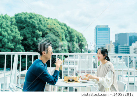 A couple enjoying coffee on their balcony 140552912