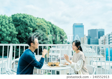 A couple enjoying coffee on their balcony A couple enjoying coffee on their balcony 140552913