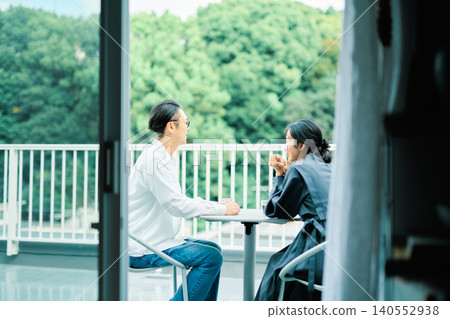 一對夫婦在陽台上享用咖啡 一對夫婦在陽台上享用咖啡 140552938