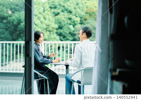 一對夫婦在陽台上享用咖啡 一對夫婦在陽台上享用咖啡 140552941