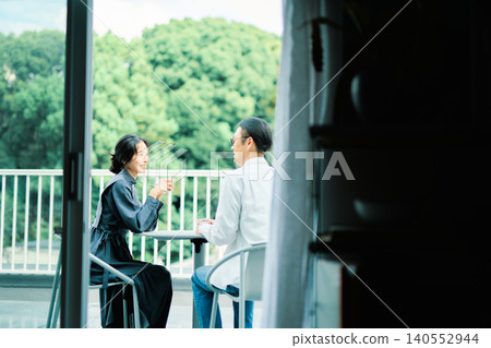 一對夫婦在陽台上享用咖啡 一對夫婦在陽台上享用咖啡 140552944