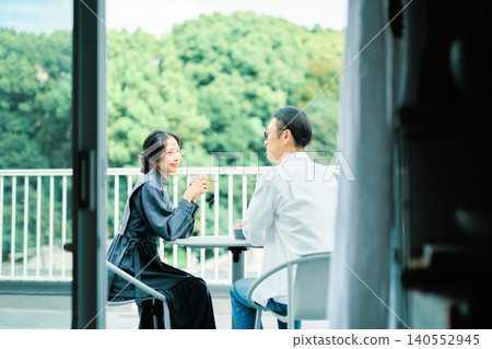 一對夫婦在陽台上享用咖啡 一對夫婦在陽台上享用咖啡 140552945