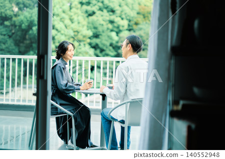 A couple enjoying coffee on their balcony A couple enjoying coffee on their balcony 140552948