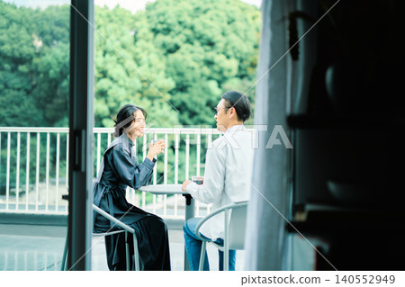 A couple enjoying coffee on their balcony A couple enjoying coffee on their balcony 140552949