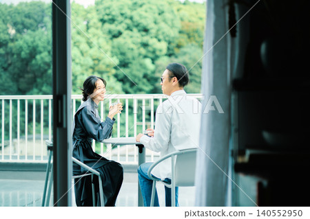 A couple enjoying coffee on their balcony 140552950