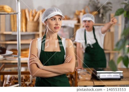 Young woman and guy sellers quarrel in bakery 140553553