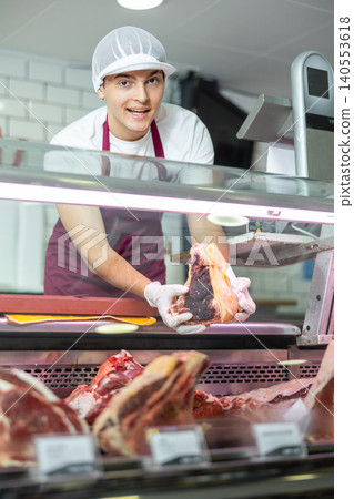 Male meat vendor provides selection 140553618