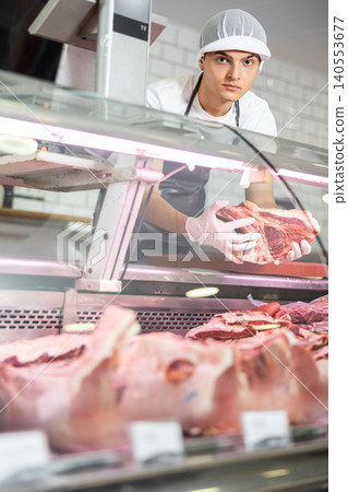 Guy seller works in specialized butcher shop Guy seller works in specialized butcher shop 140553677