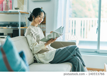 Woman relaxing in the living room Woman relaxing in the living room 140553766