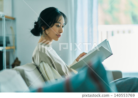 Woman relaxing in the living room Woman relaxing in the living room 140553769