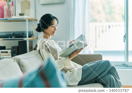 Woman relaxing in the living room Woman relaxing in the living room 140553787