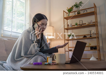 Asian woman on telehealth call with laptop and medicine at home for illness Asian woman on telehealth call with laptop and medicine at home for illness 140554001