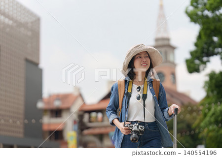 Asian woman traveling with backpack and camera exploring city for summer vacation tourism Asian woman traveling with backpack and camera exploring city for summer vacation tourism 140554196