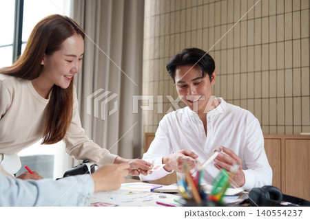 Asian business team collaborating on UI UX design creative process in modern office meeting teamwork Asian business team collaborating on UI UX design creative process in modern office meeting teamwork 140554237