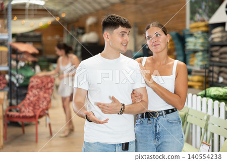 Young couple exploring furniture and accessories in garden store Young couple exploring furniture and accessories in garden store 140554238