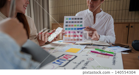 Asian business team collaborating on UI UX design creative process with color palette in modern office meeting teamwork Asian business team collaborating on UI UX design creative process with color palette in modern office meeting teamwork 140554304