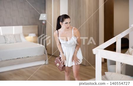 Adult woman looking around in bedroom department Adult woman looking around in bedroom department 140554727
