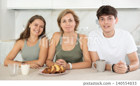 Girl and guy have nice conversation with woman, mom, during Sunday tea party Girl and guy have nice conversation with woman, mom, during Sunday tea party 140554833
