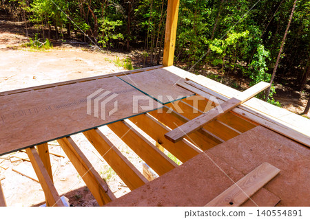 Workers are installing glass panels on wooden frames at construction site. Workers are installing glass panels on wooden frames at construction site. 140554891