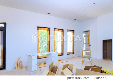 Work is being done in room with boxes, ladder, shelves, windows. natural light is coming through openings. Work is being done in room with boxes, ladder, shelves, windows. natural light is coming through openings. 140554898