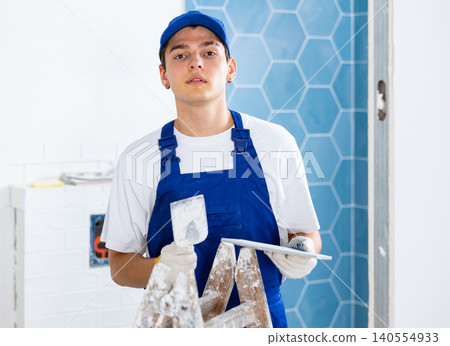 Young tiler working with ceramic tiles for interior decoration of repairable room Young tiler working with ceramic tiles for interior decoration of repairable room 140554933