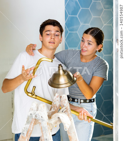 Young couple preparing shower to installation in house under renovation Young couple preparing shower to installation in house under renovation 140554987
