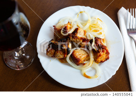 Spicy pork shashlik with fresh onion on plate 140555041