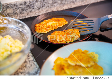 Preparation of potato pancakes on frying pan 140555223