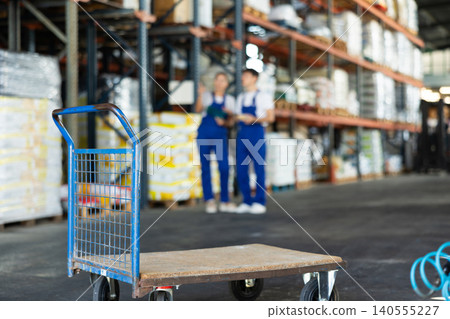 Large cargo trolley stands in premises of store-warehouse of construction and repair materials. Large cargo trolley stands in premises of store-warehouse of construction and repair materials. 140555227