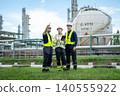 Team of engineers collaborating at chemical plant industrial site professional meeting outdoor strategic planning 140555922