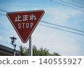 A bright red stop sign stands out against the blue sky: Japanese traffic signs 140555927