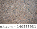 Cracks running through the warm, exposed aggregate concrete – the texture of aging ground. 140555931