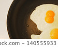 A pan-fried egg with twin eggs: A cooking scene full of everyday life. 140555933