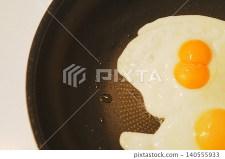 A pan-fried egg with twin eggs: A cooking scene full of everyday life. A pan-fried egg with twin eggs: A cooking scene full of everyday life. 140555933