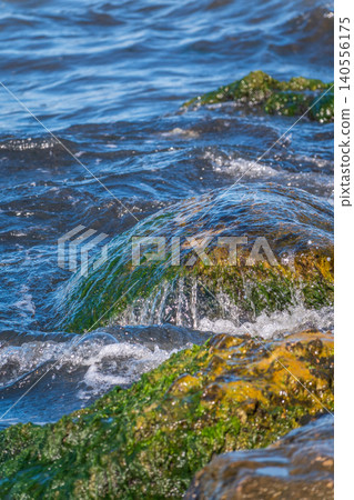 Sea water splashing over the stones on the beach Sea water splashing over the stones on the beach 140556175