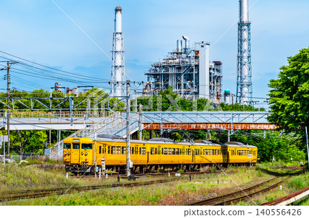 一列 115 系列列車行駛在山陽本線上,背景是一座煉油廠,靠近櫛濱站。 一列 115 系列列車行駛在山陽本線上,背景是一座煉油廠,靠近櫛濱站。 140556426