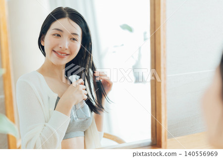 Women using hair styling water 140556969