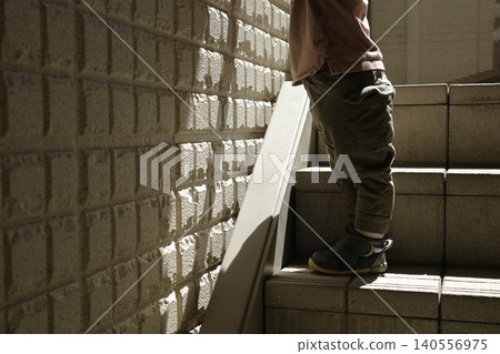 The feet of a child standing on the stairs and the tiled wall The feet of a child standing on the stairs and the tiled wall 140556975