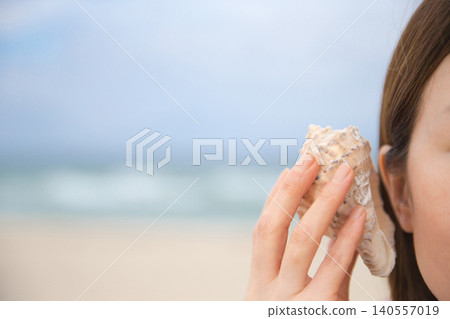 A woman listening to the sound of the sea in Sora A woman listening to the sound of the sea in Sora 140557019
