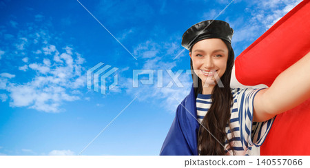 Woman expresses joy while holding flag. Freedom and travel concept in vibrant atmosphere 140557066