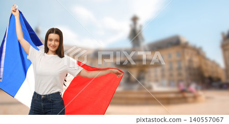 Woman waves French flag in lively city square. Celebration and travel concept Woman waves French flag in lively city square. Celebration and travel concept 140557067