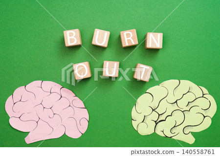 Burnout word on wooden blocks with paper brains on green background Burnout word on wooden blocks with paper brains on green background 140558761