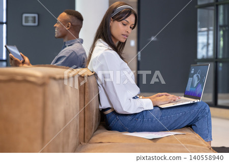 Diverse coworkers working on documents using laptop and tablet in office lounge, copy space 140558940