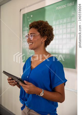 African american woman teaching chemistry with periodic table and with tab in chemistry lab African american woman teaching chemistry with periodic table and with tab in chemistry lab 140559004